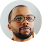 Portrait of a man with glasses and a beard against a plain white background.